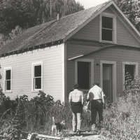 Two men walking towards a house